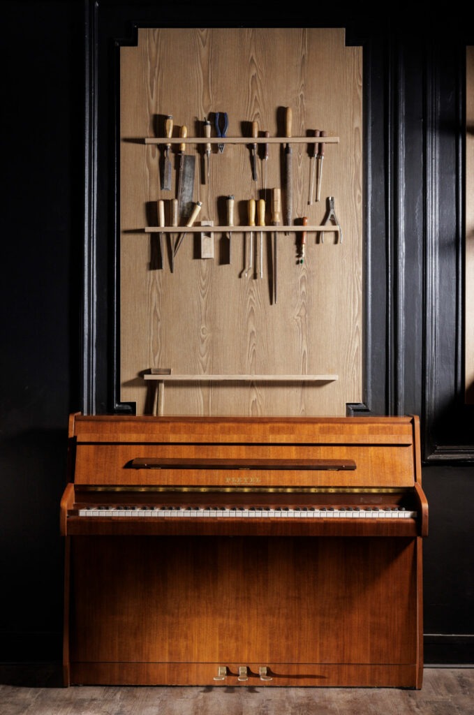 Piano droit en bois, atelier en arrière-plan