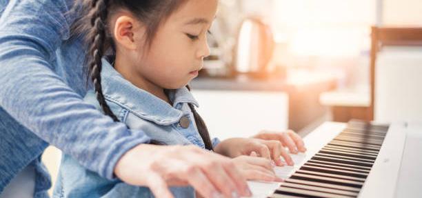 Jeune fille jouant du piano, concentrée sur les touches