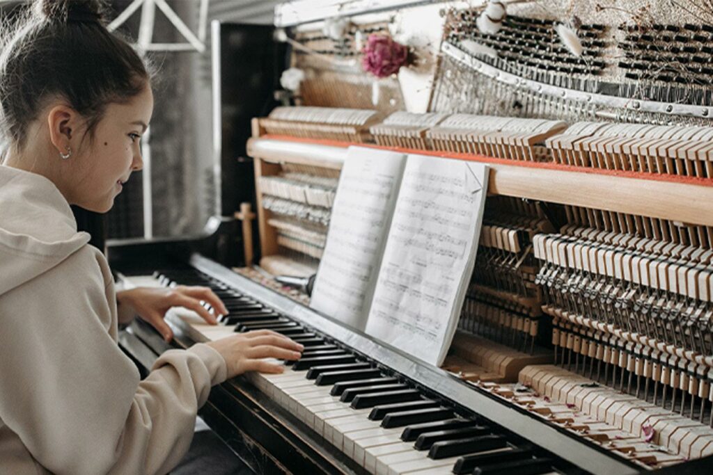 Jeune fille jouant du piano avec une partition ouverte